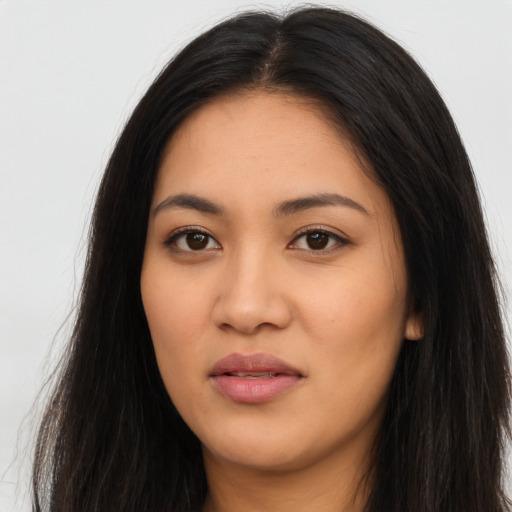 Joyful latino young-adult female with long  brown hair and brown eyes