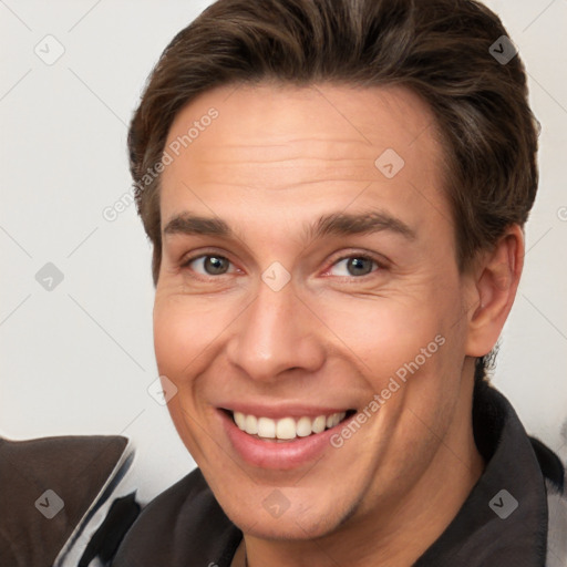 Joyful white adult male with short  brown hair and brown eyes