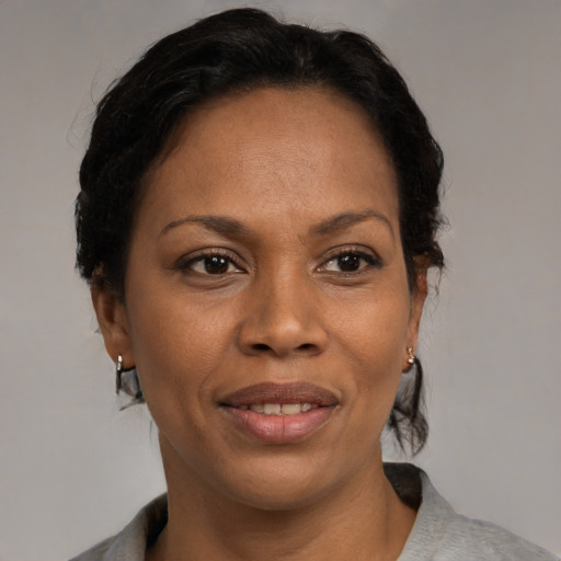 Joyful black adult female with medium  brown hair and brown eyes