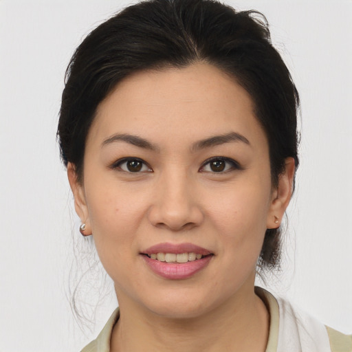 Joyful latino young-adult female with medium  brown hair and brown eyes