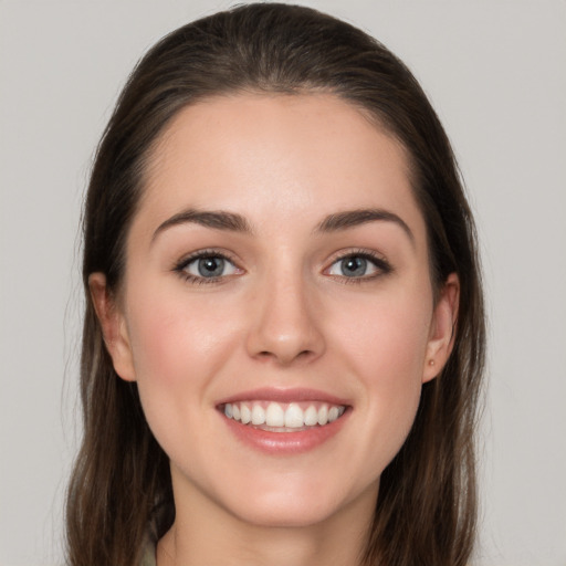 Joyful white young-adult female with long  brown hair and grey eyes