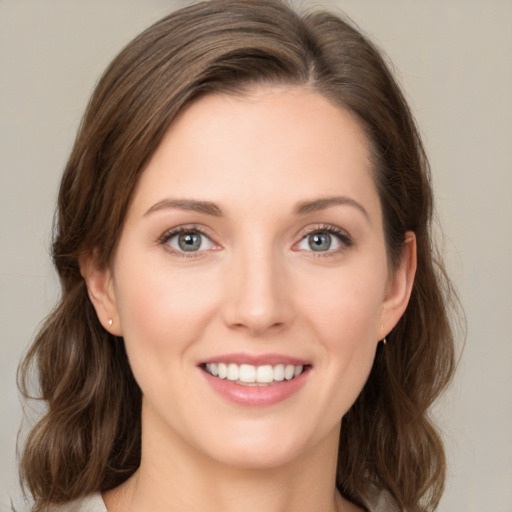 Joyful white young-adult female with medium  brown hair and green eyes