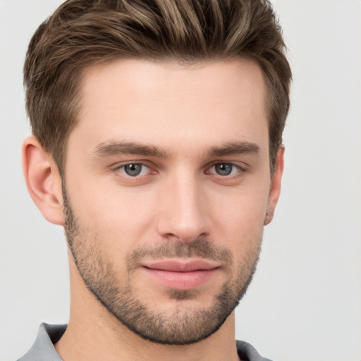 Joyful white young-adult male with short  brown hair and grey eyes