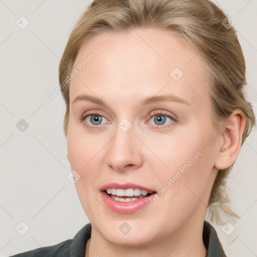 Joyful white young-adult female with medium  brown hair and blue eyes