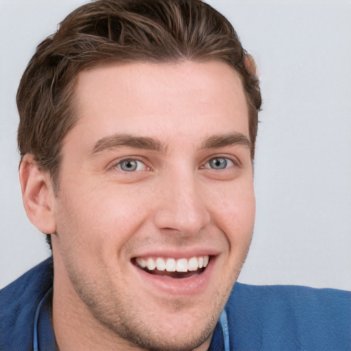 Joyful white young-adult male with short  brown hair and blue eyes