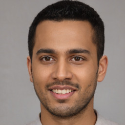 Joyful latino young-adult male with short  black hair and brown eyes