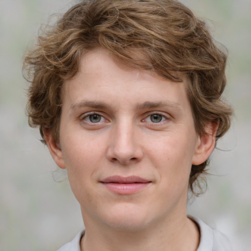 Joyful white young-adult male with medium  brown hair and green eyes