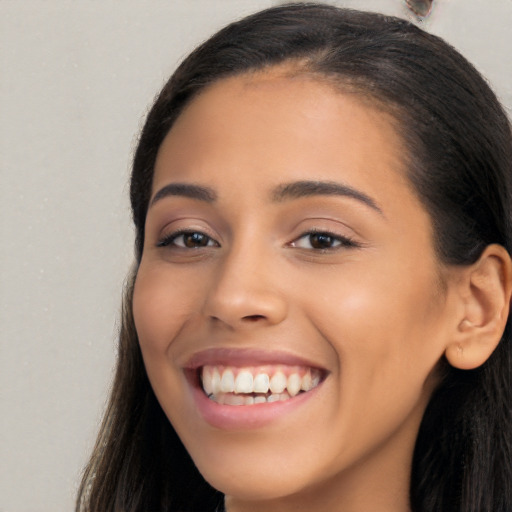 Joyful latino young-adult female with long  brown hair and brown eyes