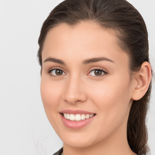 Joyful white young-adult female with long  brown hair and brown eyes