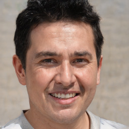 Joyful white adult male with short  brown hair and brown eyes