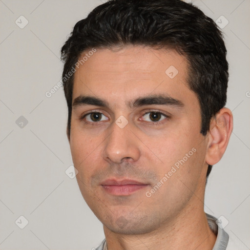 Joyful white young-adult male with short  black hair and brown eyes