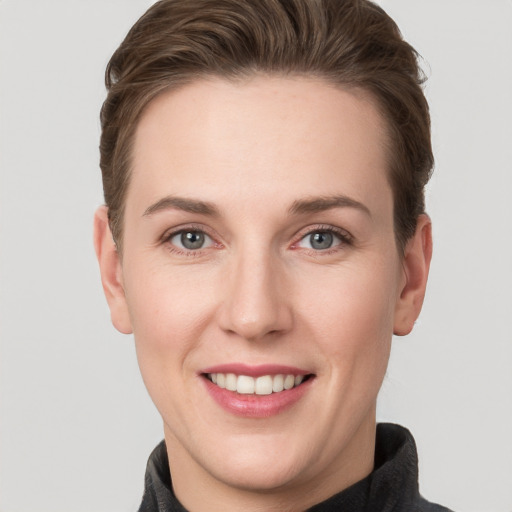 Joyful white young-adult female with short  brown hair and grey eyes