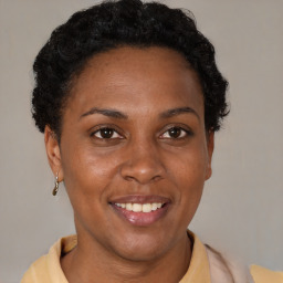 Joyful black adult female with short  brown hair and brown eyes