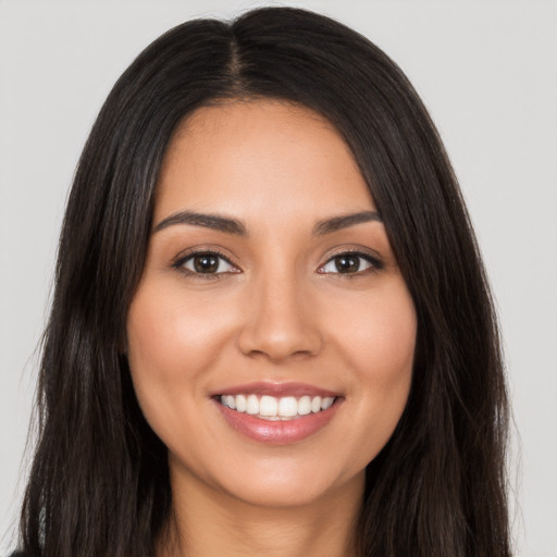 Joyful latino young-adult female with long  brown hair and brown eyes