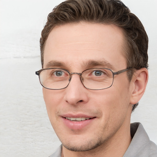 Joyful white adult male with short  brown hair and blue eyes