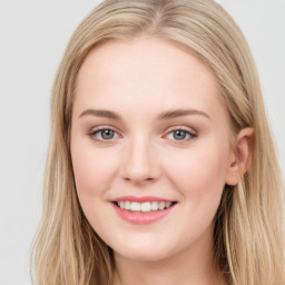 Joyful white young-adult female with long  brown hair and blue eyes