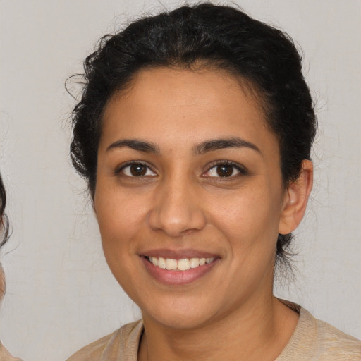 Joyful latino young-adult female with short  brown hair and brown eyes