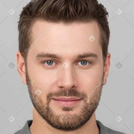 Joyful white young-adult male with short  brown hair and grey eyes