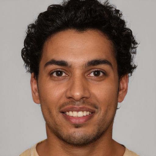 Joyful latino young-adult male with short  brown hair and brown eyes