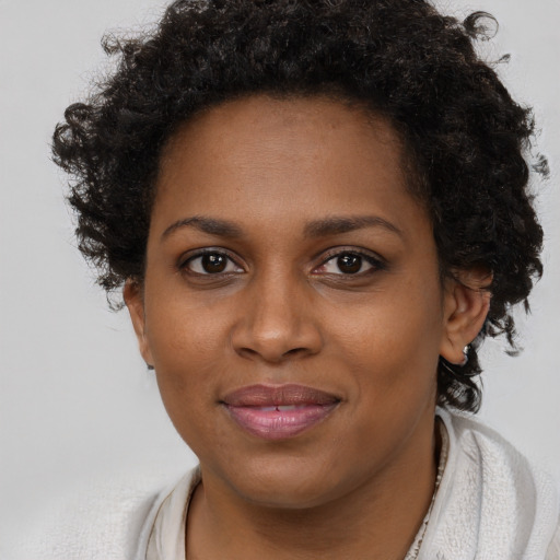 Joyful black young-adult female with short  brown hair and brown eyes