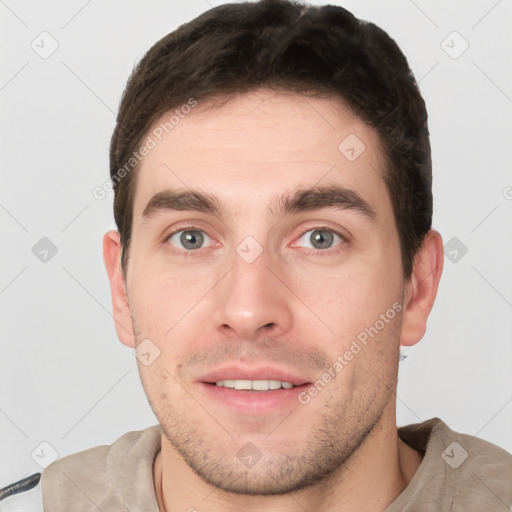 Joyful white young-adult male with short  brown hair and grey eyes