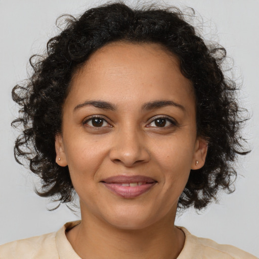 Joyful black young-adult female with medium  brown hair and brown eyes