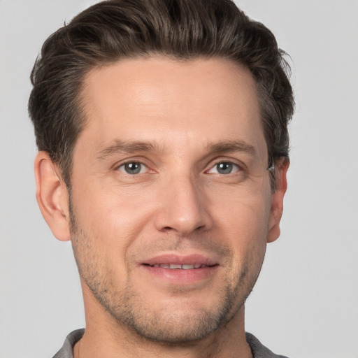 Joyful white adult male with short  brown hair and brown eyes