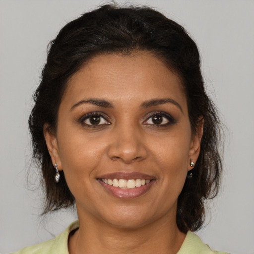 Joyful black young-adult female with medium  brown hair and brown eyes
