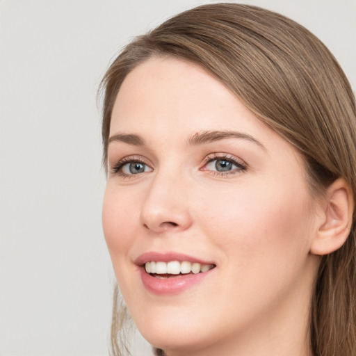 Joyful white young-adult female with long  brown hair and grey eyes