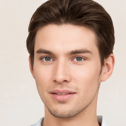 Joyful white young-adult male with short  brown hair and grey eyes