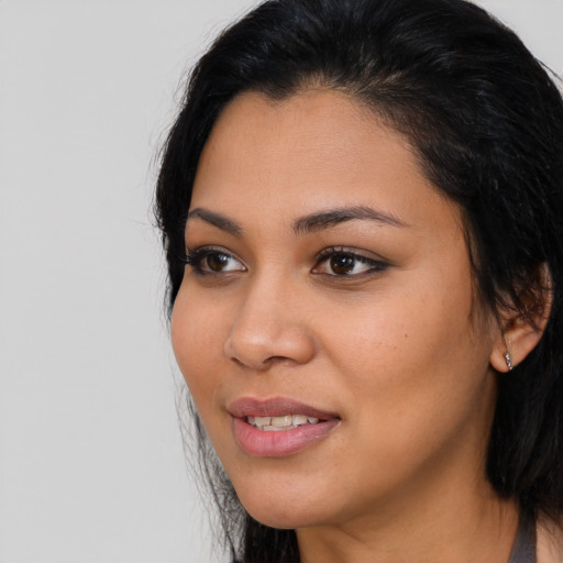 Joyful latino young-adult female with long  black hair and brown eyes