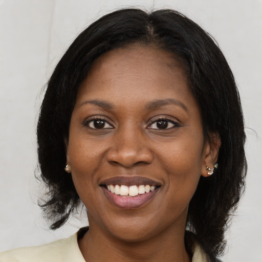 Joyful black young-adult female with medium  brown hair and brown eyes