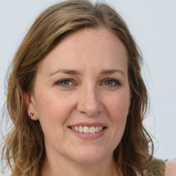 Joyful white adult female with long  brown hair and green eyes