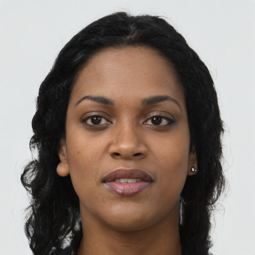 Joyful black young-adult female with long  black hair and brown eyes