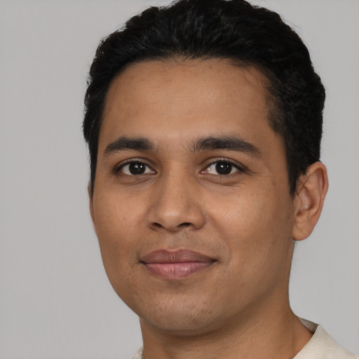 Joyful latino young-adult male with short  black hair and brown eyes