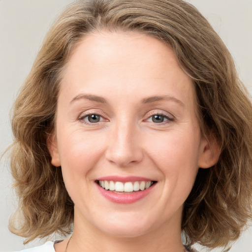 Joyful white young-adult female with medium  brown hair and green eyes