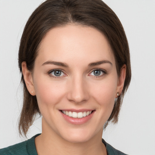 Joyful white young-adult female with medium  brown hair and grey eyes