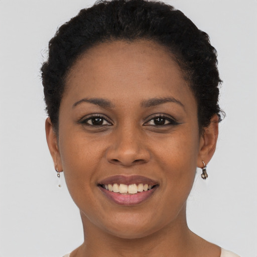 Joyful black young-adult female with short  brown hair and brown eyes