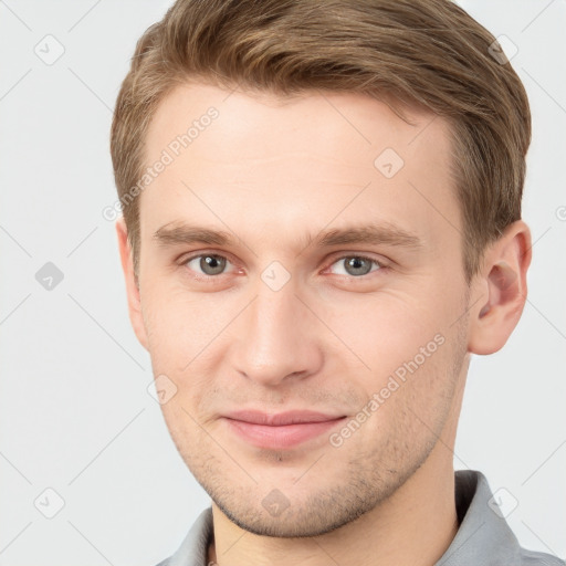 Joyful white young-adult male with short  brown hair and grey eyes