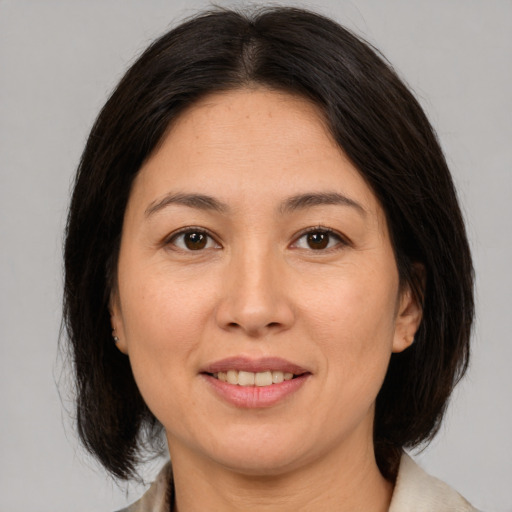 Joyful asian adult female with medium  brown hair and brown eyes