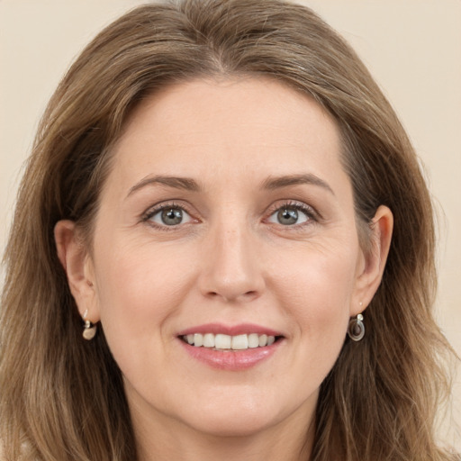 Joyful white young-adult female with long  brown hair and green eyes