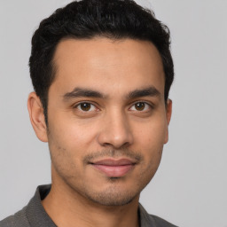 Joyful latino young-adult male with short  brown hair and brown eyes