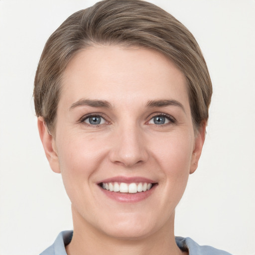 Joyful white young-adult female with short  brown hair and grey eyes