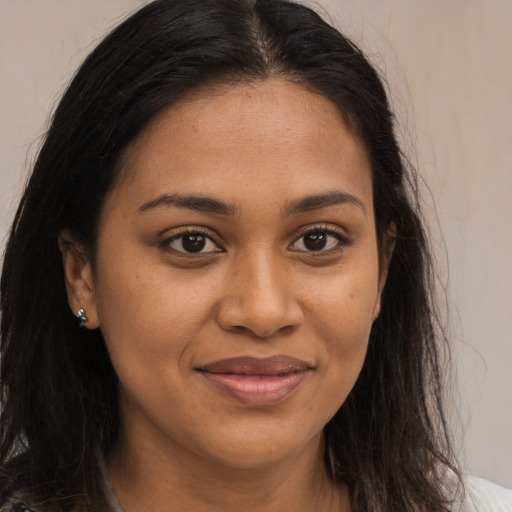 Joyful black young-adult female with long  brown hair and brown eyes