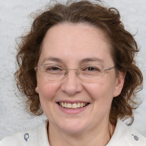 Joyful white adult female with medium  brown hair and blue eyes