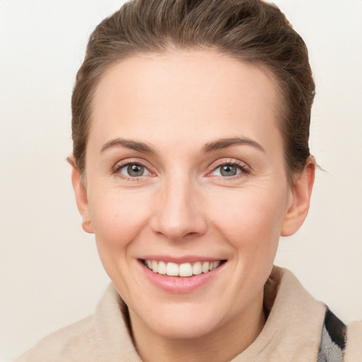 Joyful white young-adult female with short  brown hair and grey eyes