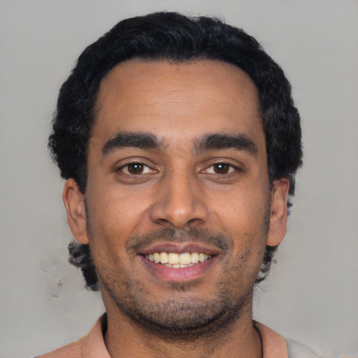 Joyful black young-adult male with short  black hair and brown eyes