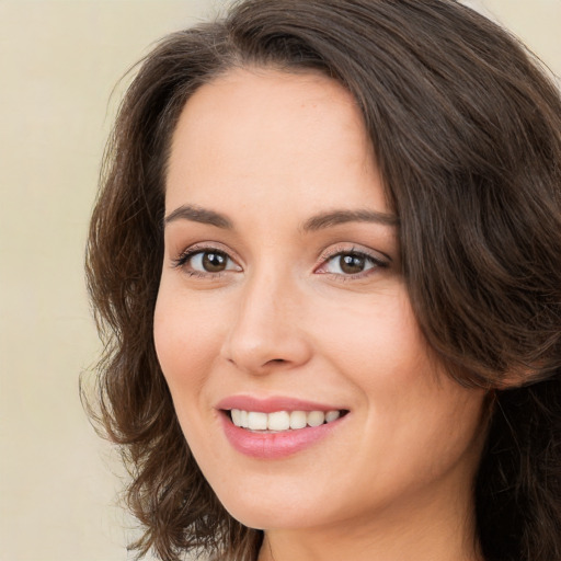 Joyful white young-adult female with long  brown hair and brown eyes