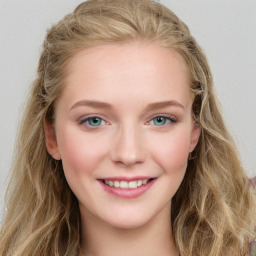 Joyful white young-adult female with long  brown hair and blue eyes