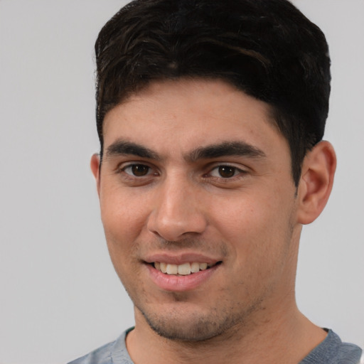 Joyful white young-adult male with short  black hair and brown eyes